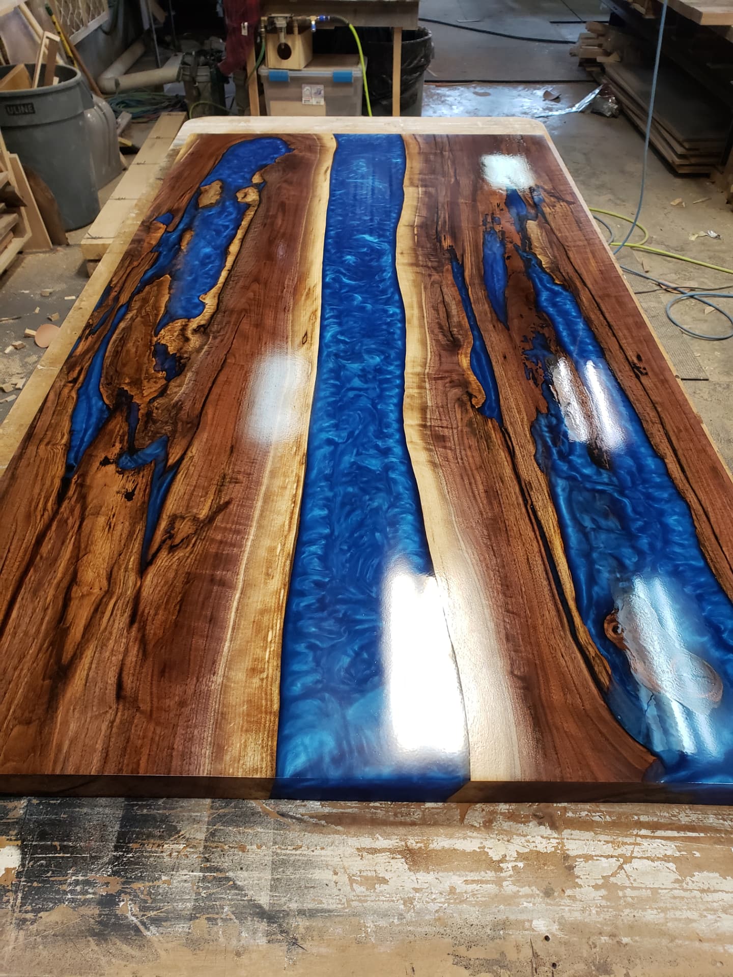 Live edge walnut slab table with blue epoxy resin at OSL Hardwood Store